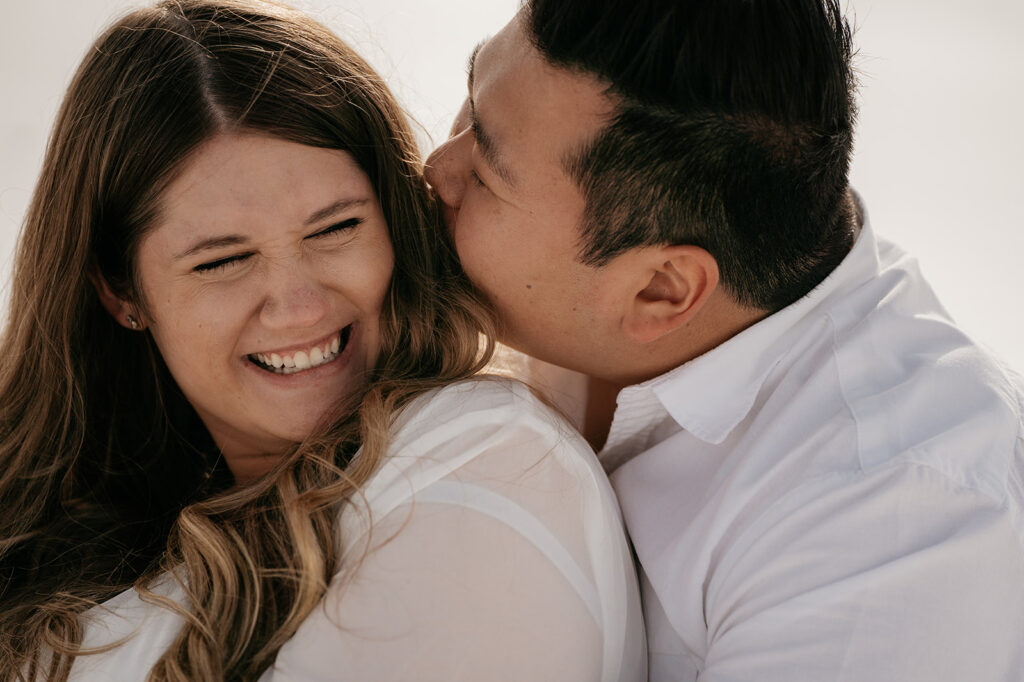 Couple laughing and embracing joyfully.