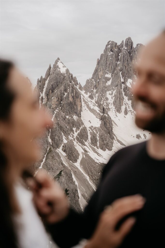 Blurry couple smiling with snowy mountain backdrop
