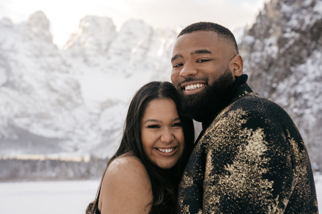 Couple smiling in snowy mountain landscape