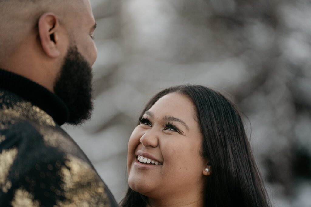 Woman smiling at man outdoors.