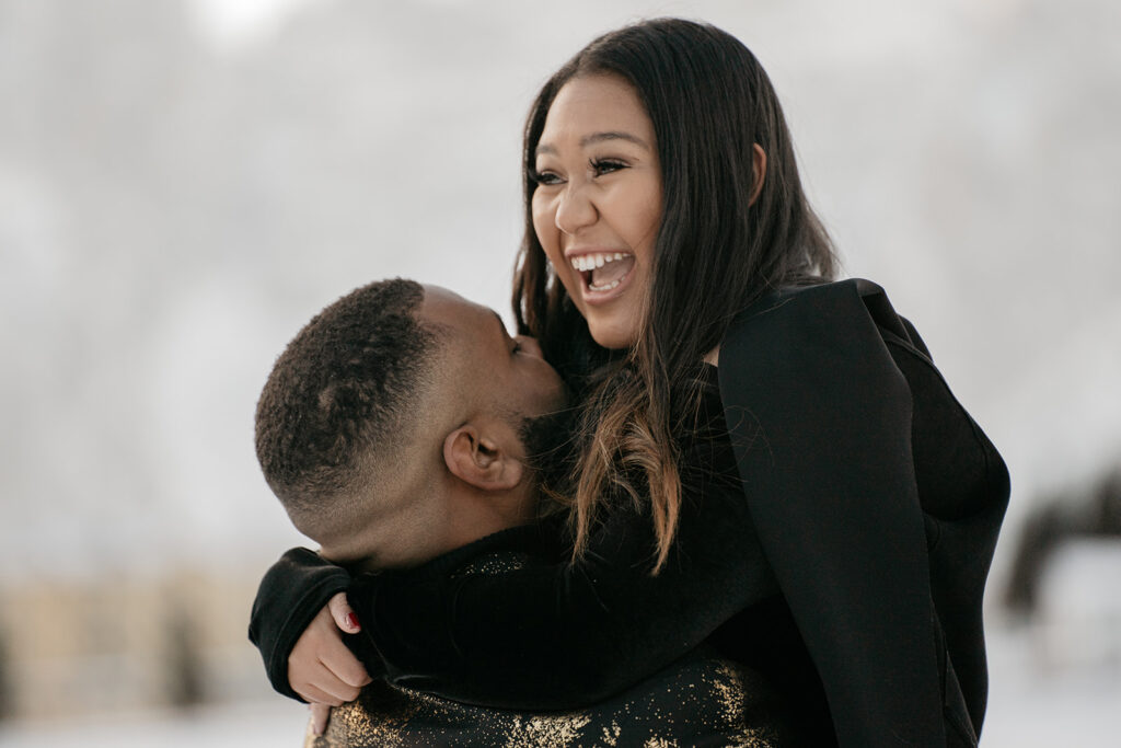 Couple hugging and laughing outdoors.