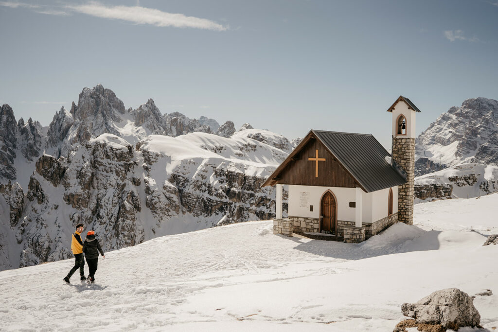 Snowy mountain chapel with hikers