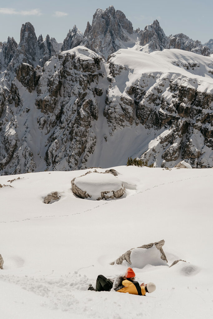 People relaxing on snowy mountain with rock formations