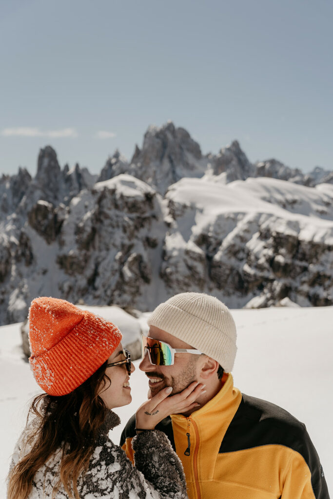 Couple smiling on snowy mountain landscape