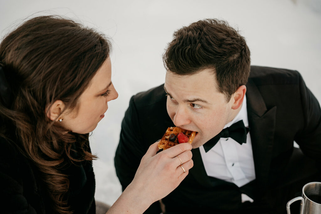 Couple sharing waffle with berries in winter.