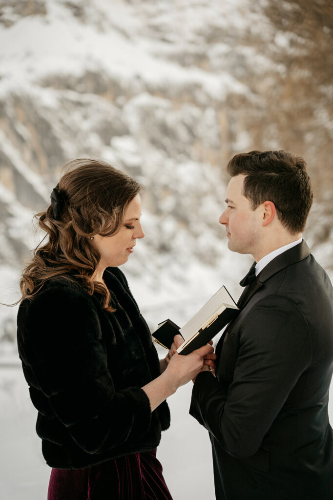 Couple exchanging vows outdoors in snowy setting.