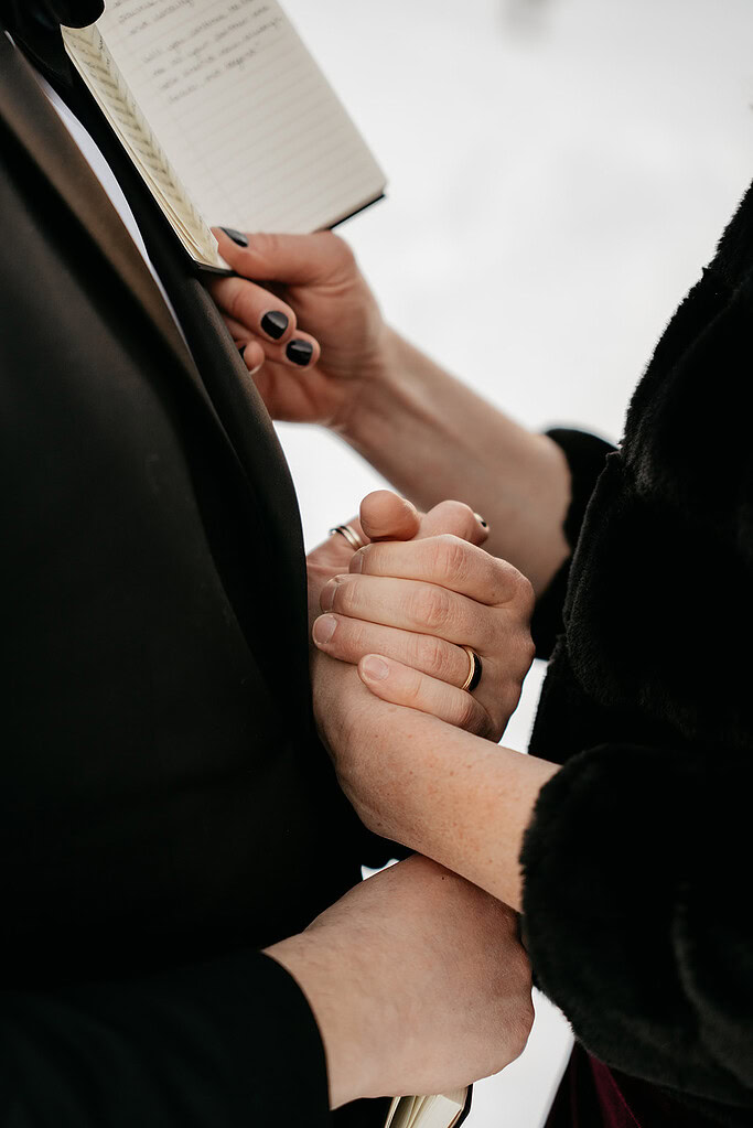 Couple holding hands during wedding ceremony.