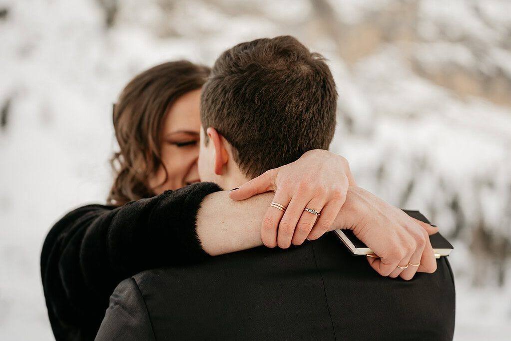 Couple embracing in snowy landscape.