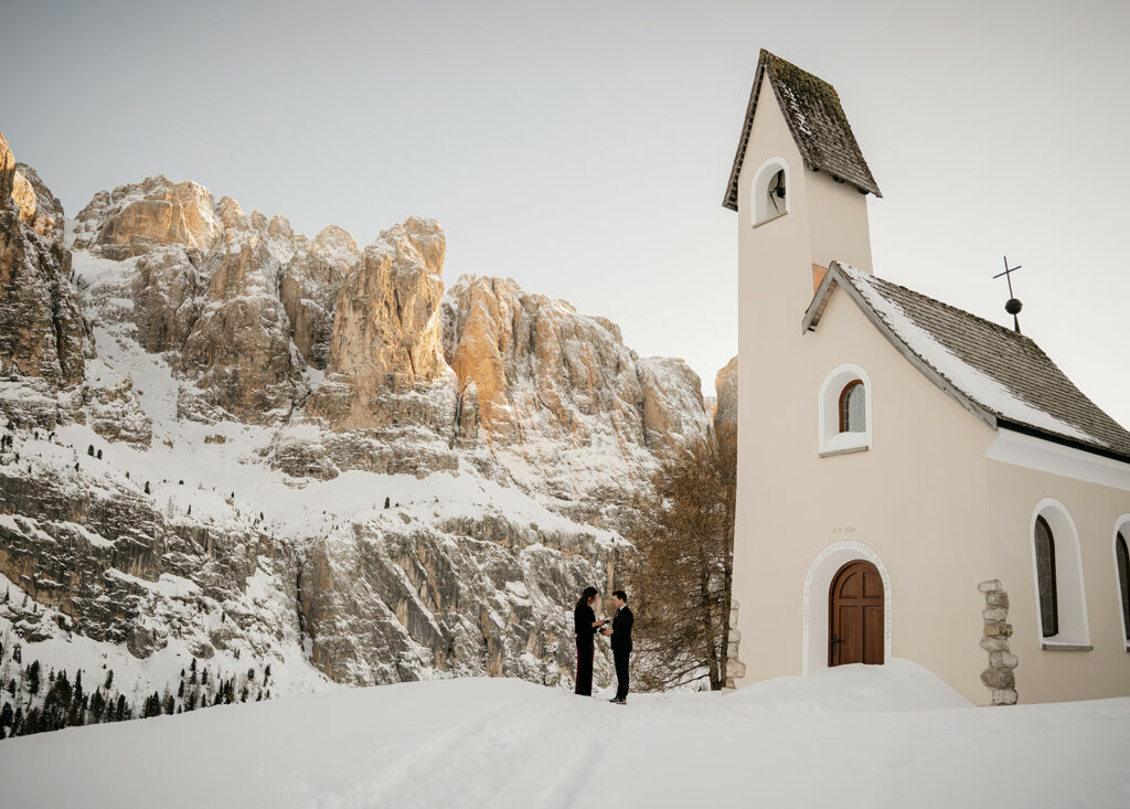 Snowy mountain chapel with people outside