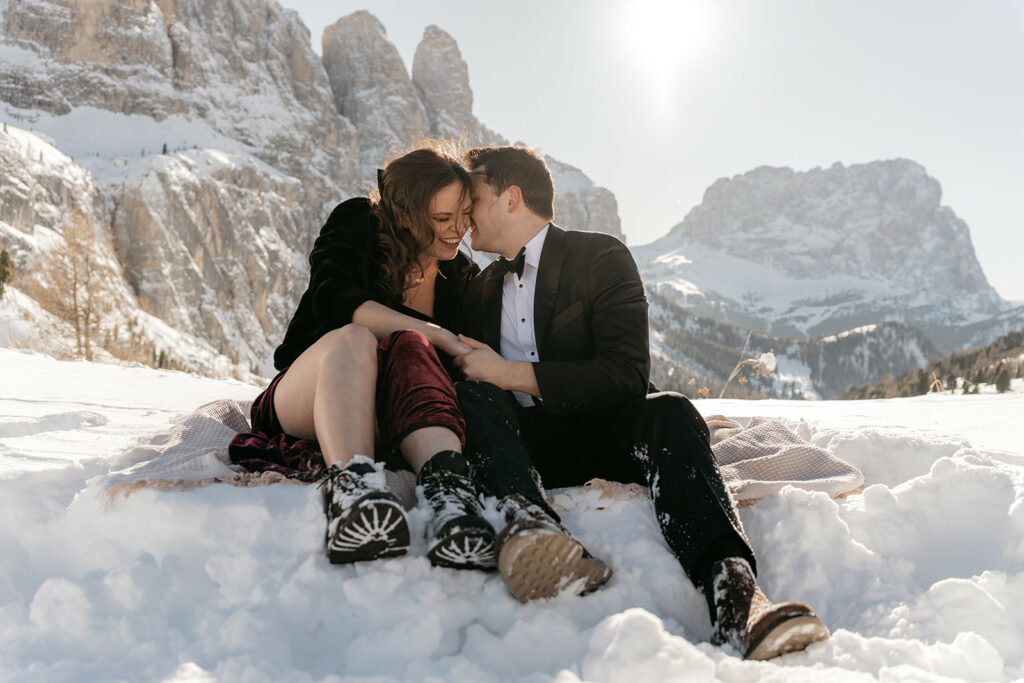 Couple cuddling in snowy mountain landscape
