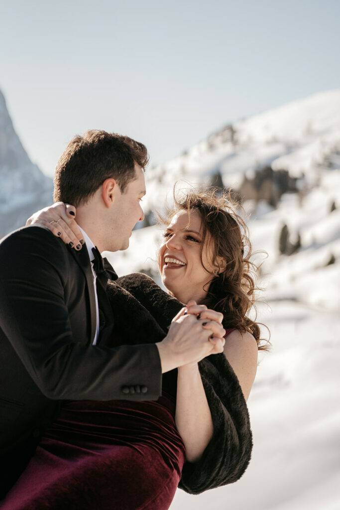 Couple dancing in snowy mountain scenery.