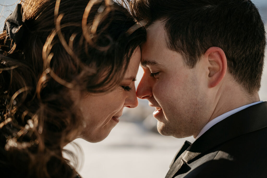 Couple touching foreheads, smiling, close-up.