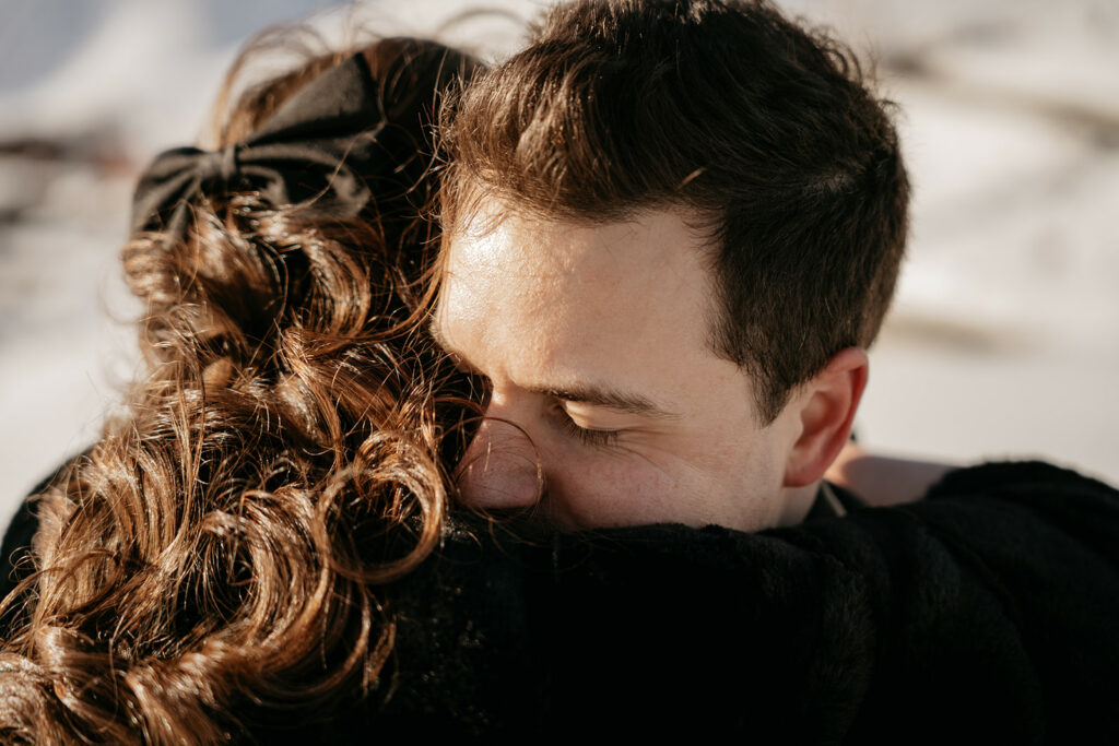 Close embrace outdoors in sunlight.