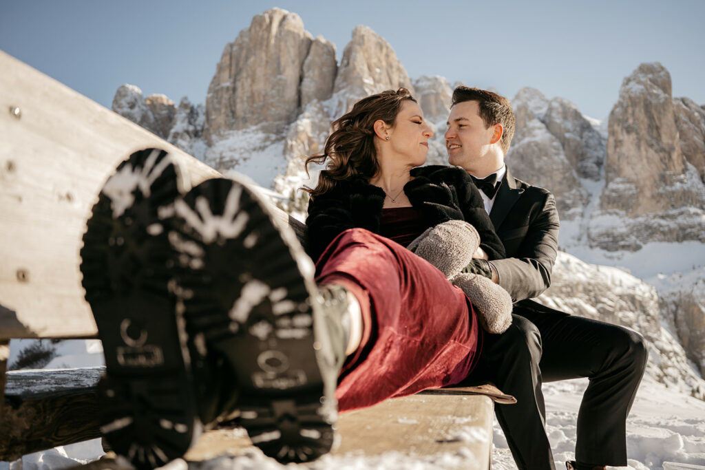Couple sitting on bench in snowy mountains