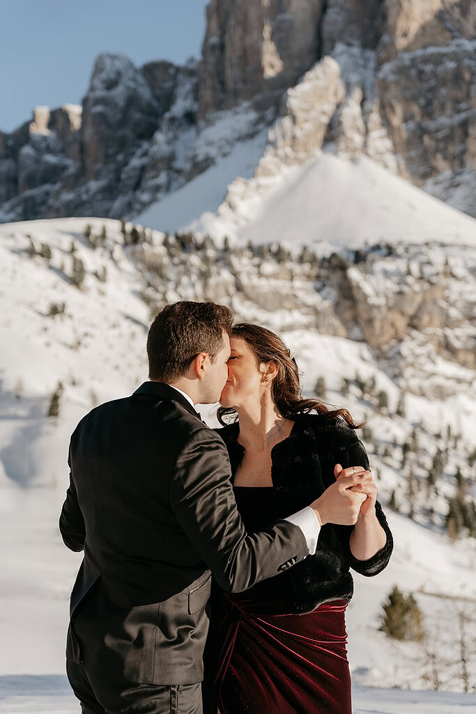 Couple kissing in snowy mountain landscape