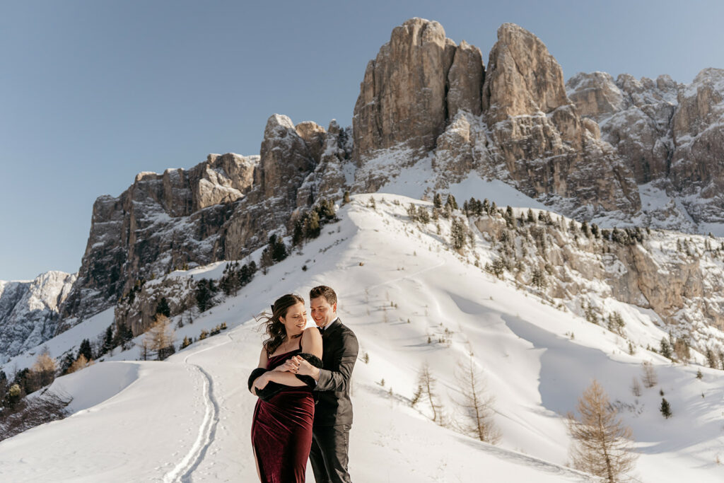 Couple embraces on snowy mountain landscape