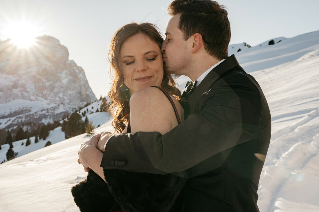 Couple embraces in snowy mountain landscape