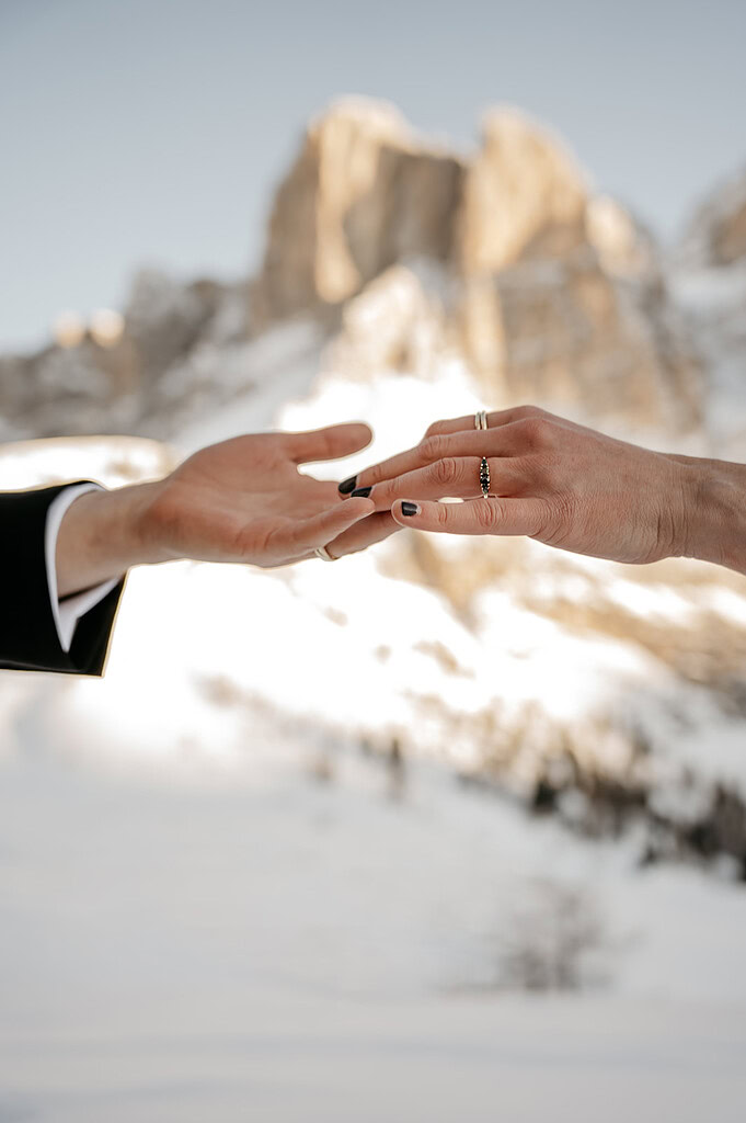 Hands reaching each other in snowy mountains.
