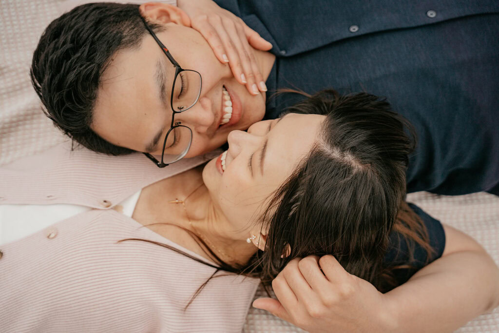 Couple smiling and lying together, close-up view.