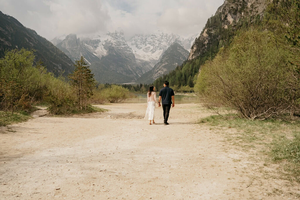 Couple walking in scenic mountain landscape.
