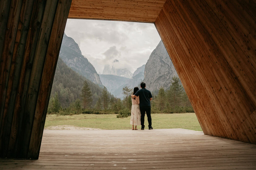 Couple enjoying mountain view from wooden cabin