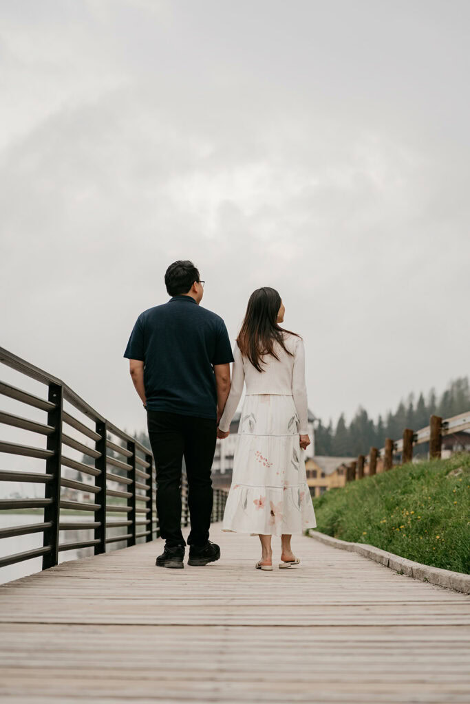 Couple holding hands on wooden pathway
