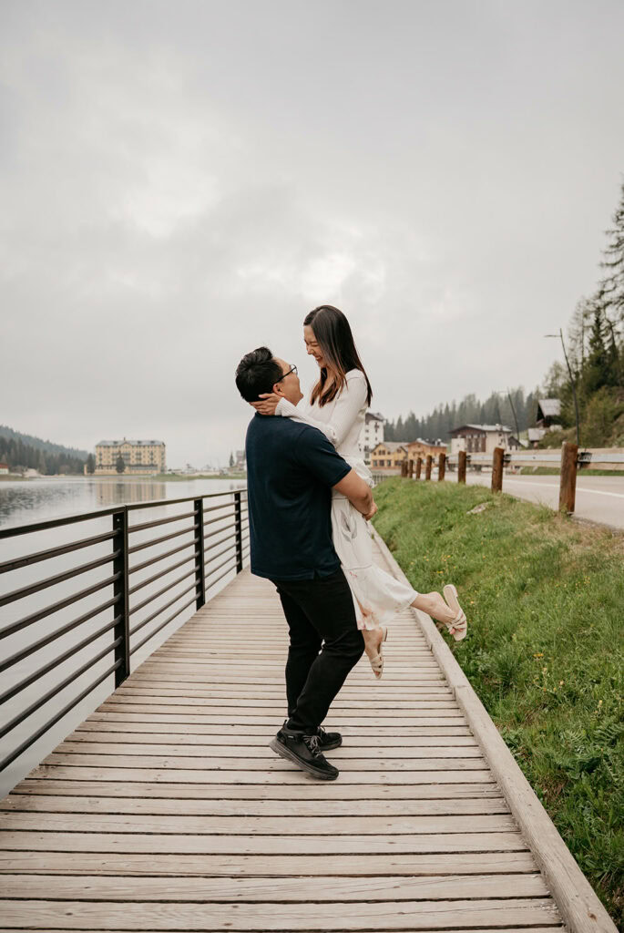 Couple embracing on lakeside boardwalk