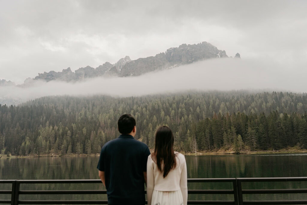 Couple enjoying misty mountain lake view.
