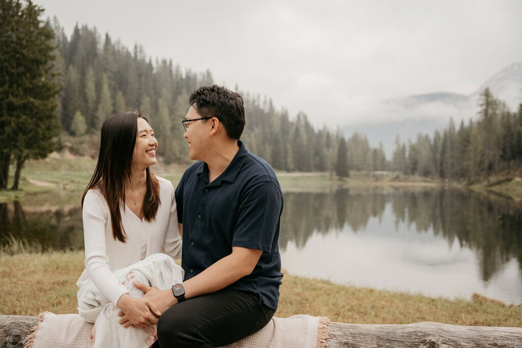 Couple smiling by serene lake in forest landscape