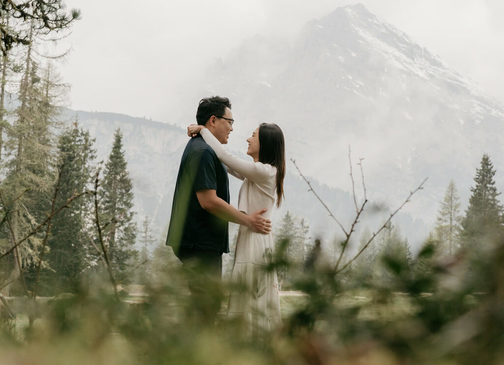 Couple embracing in scenic mountain landscape.