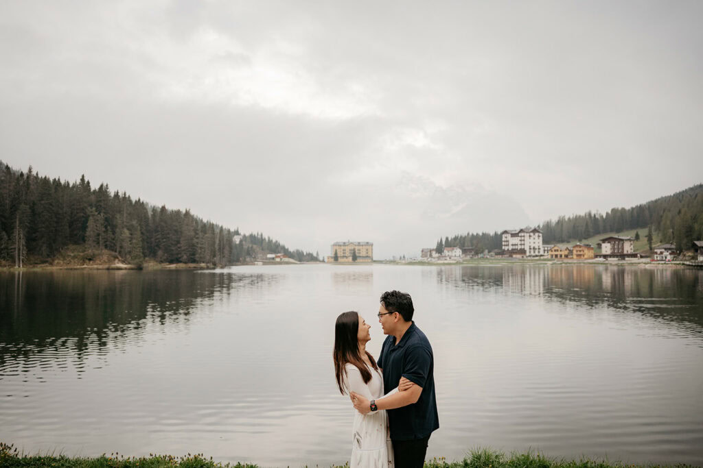 Couple embracing by a scenic lake view.