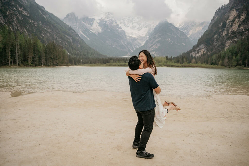 Couple embraces by scenic mountain lake.