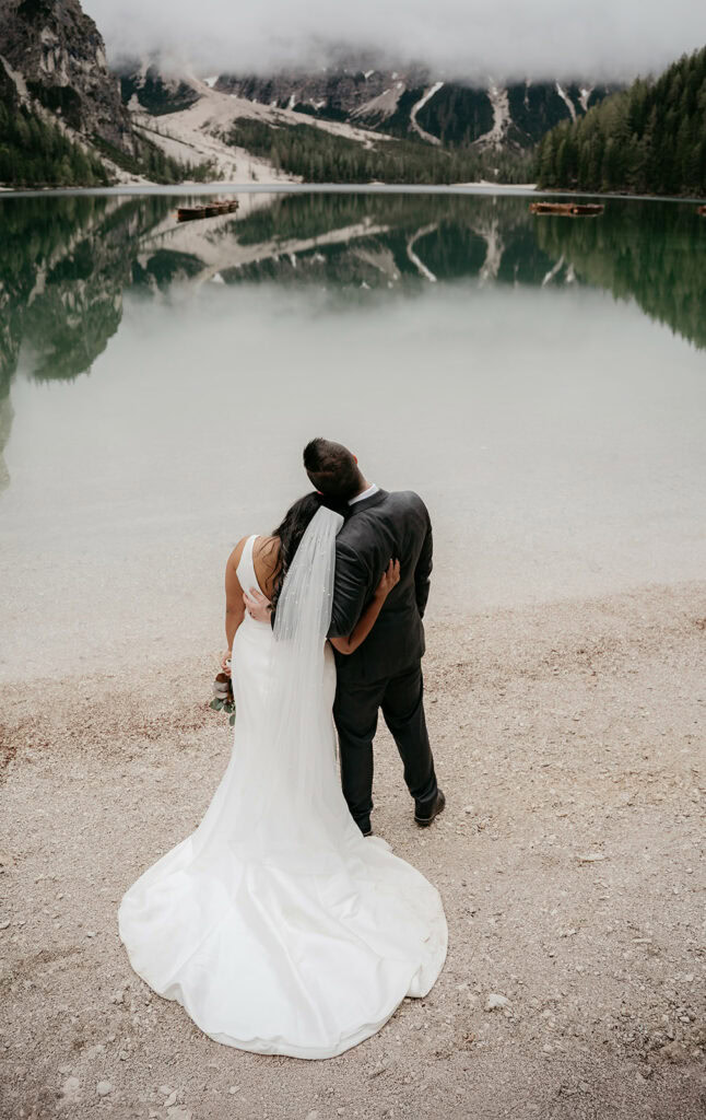 Bride and groom by scenic lake landscape