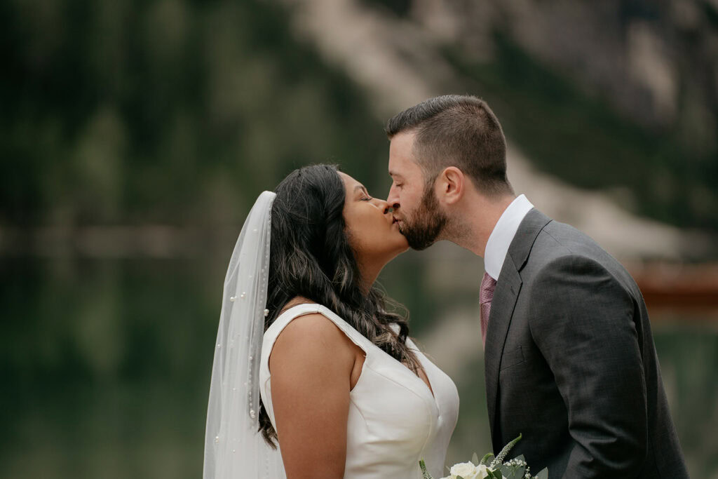 Bride and groom kissing in nature.