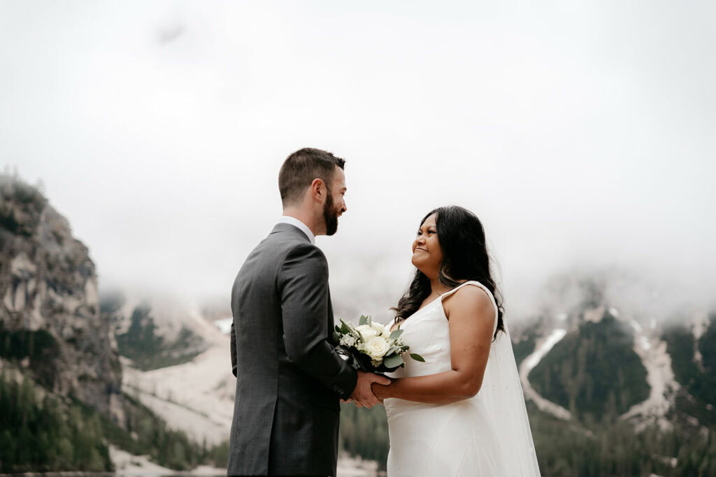 Bride and groom smiling in mountain landscape