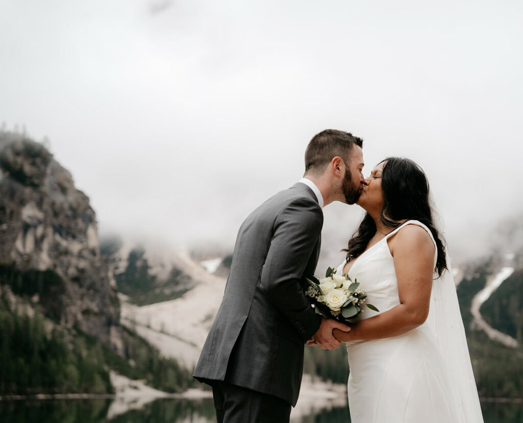 Couple kissing at mountain wedding ceremony.