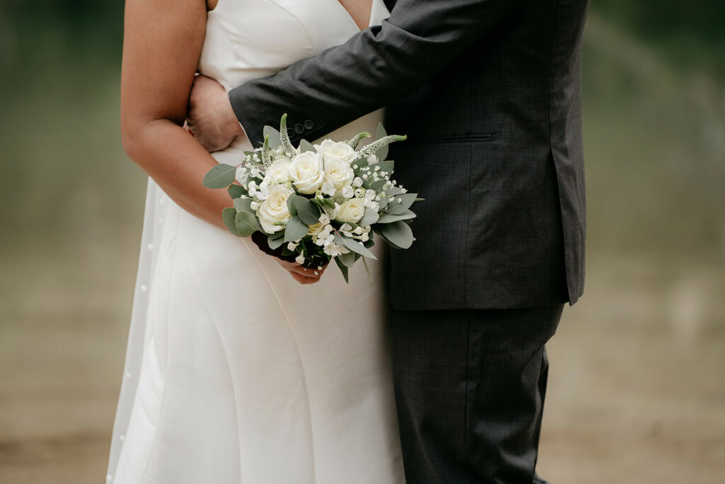 Couple embracing with white rose bouquet