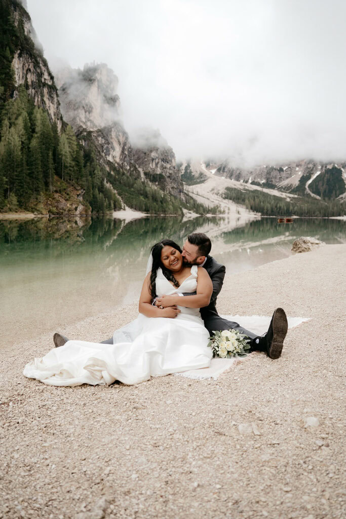 Couple embraces at scenic mountain lake.
