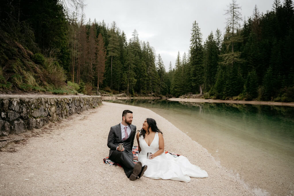 Couple sitting by a serene forest lake.