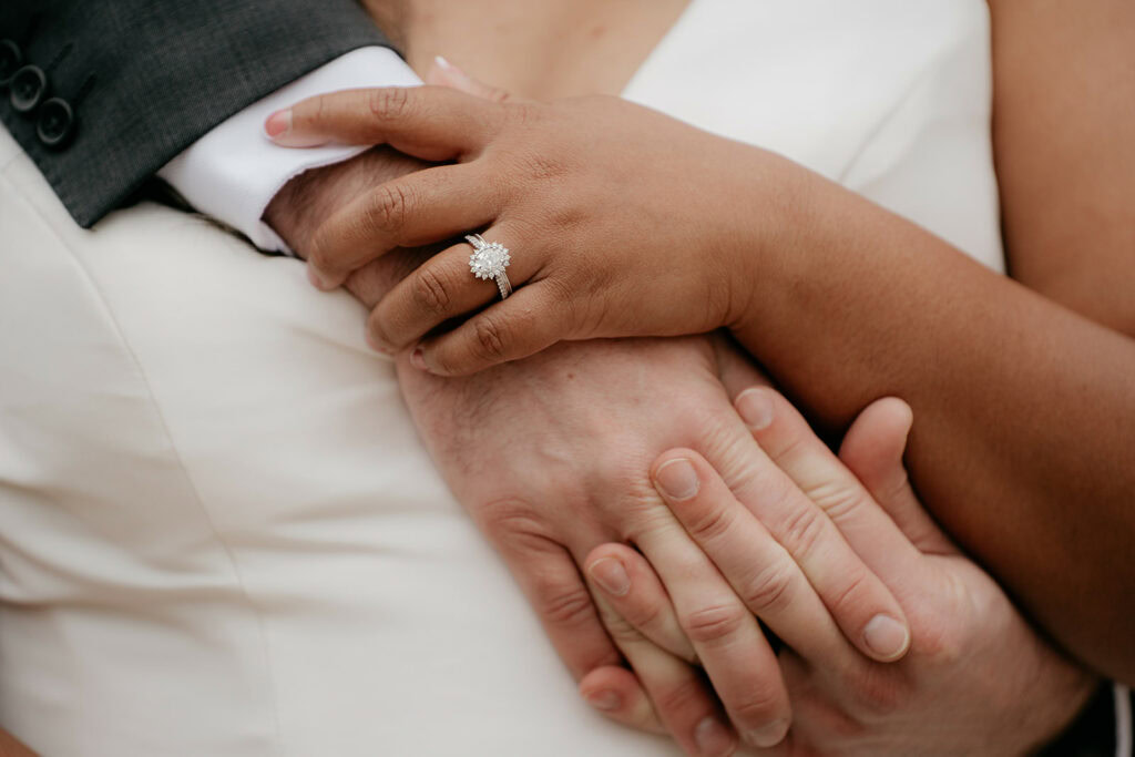 Close-up of couple's hands with engagement ring.