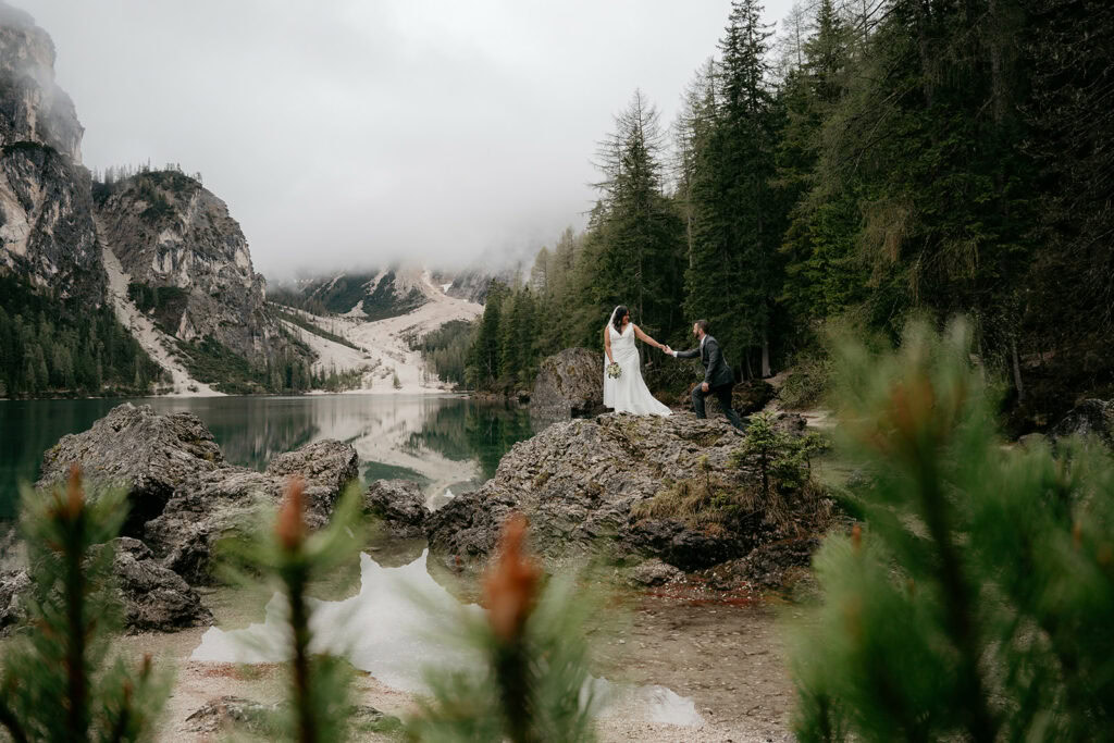 Bride and groom on rocky lake shore