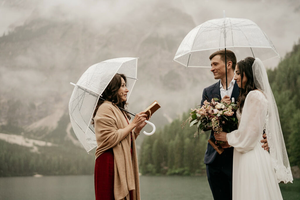 Outdoor wedding ceremony in rainy misty setting.