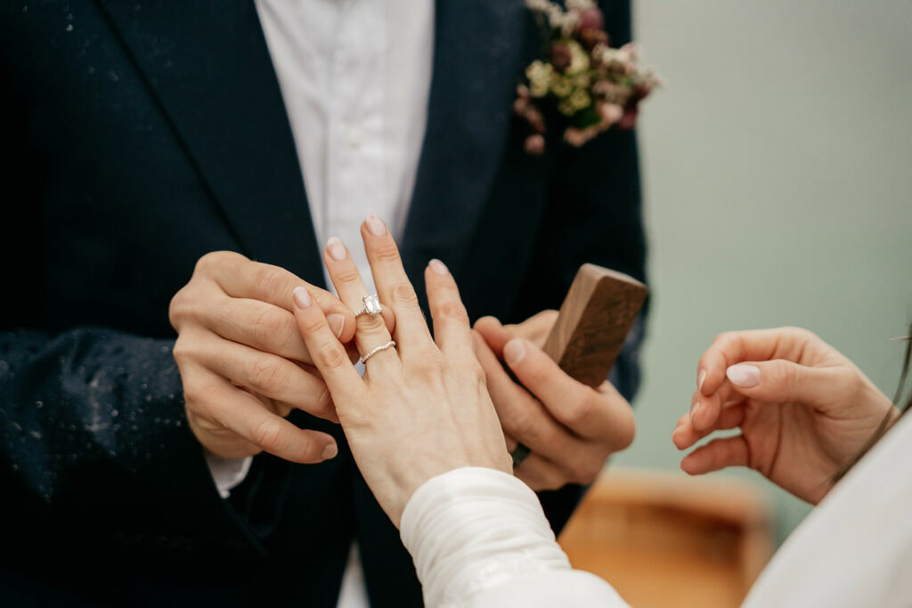 Bride and groom exchanging wedding rings.