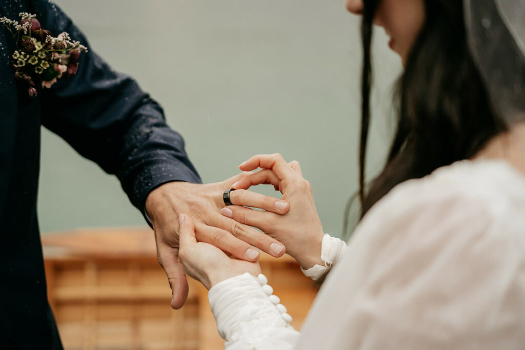 Couple exchanging wedding rings outdoors
