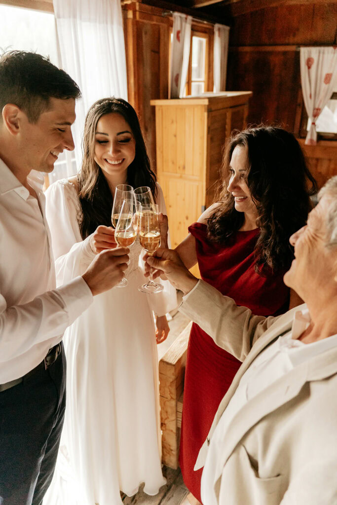 Group celebrating with champagne toasts indoors.