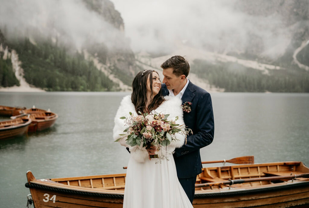 Bride and groom by lake with boats