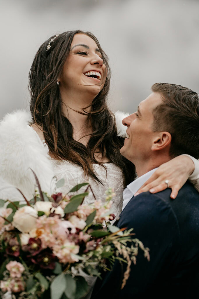 Smiling couple with bouquet on wedding day.