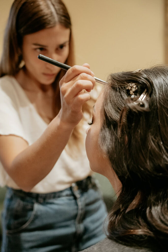 Makeup artist applying eyeliner to a client
