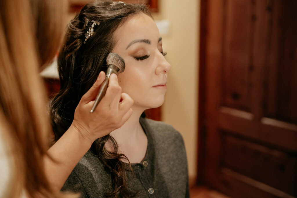 Woman getting makeup applied with brush