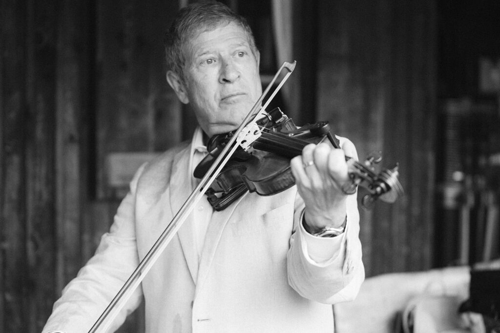 Man playing violin in black and white photo.